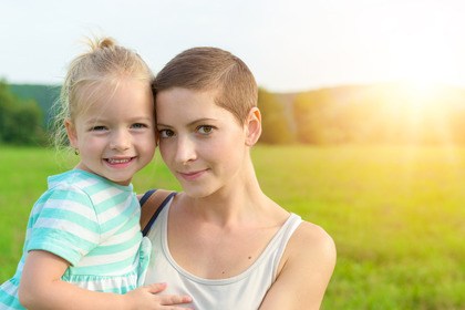 Adorable jeune fille souriant dans la bras de sa maman