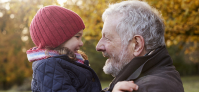 Petite-fille câline son grand-père lors d'une promenade d’automne